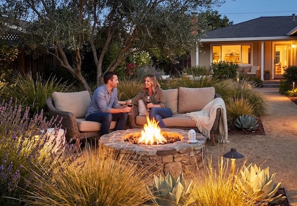 Couple enjoying a Yardzen-designed backyard with fire pit